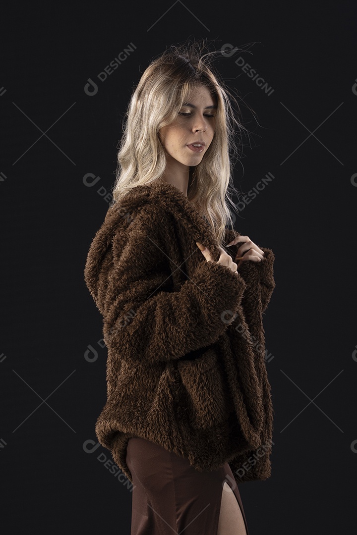 Jovem loira usando um vestido luxuoso em um fundo preto