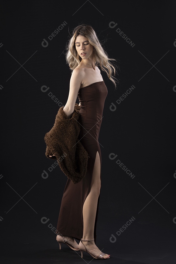 Jovem loira usando um vestido luxuoso em um fundo preto