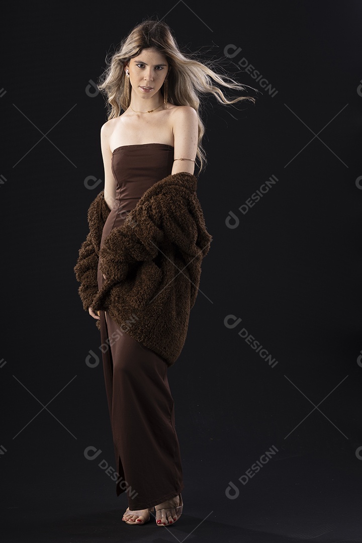 Jovem loira usando um vestido luxuoso em um fundo preto