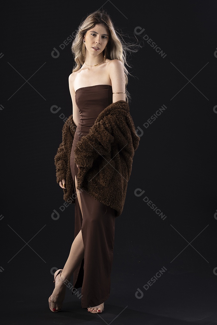Jovem loira usando um vestido luxuoso em um fundo preto