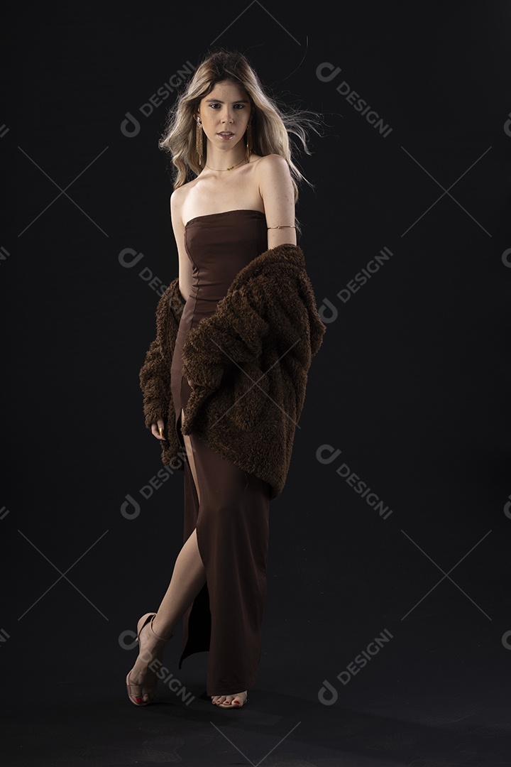 Jovem loira usando um vestido luxuoso em um fundo preto