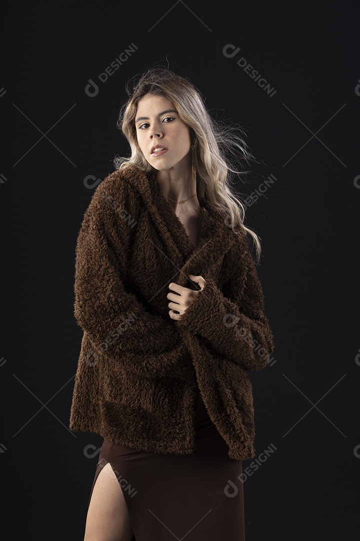 Jovem loira usando um vestido luxuoso em um fundo preto