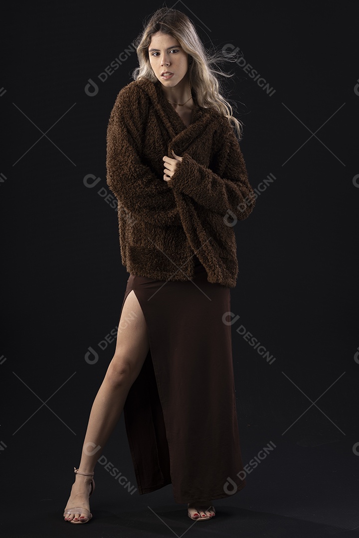 Jovem loira usando um vestido luxuoso em um fundo preto