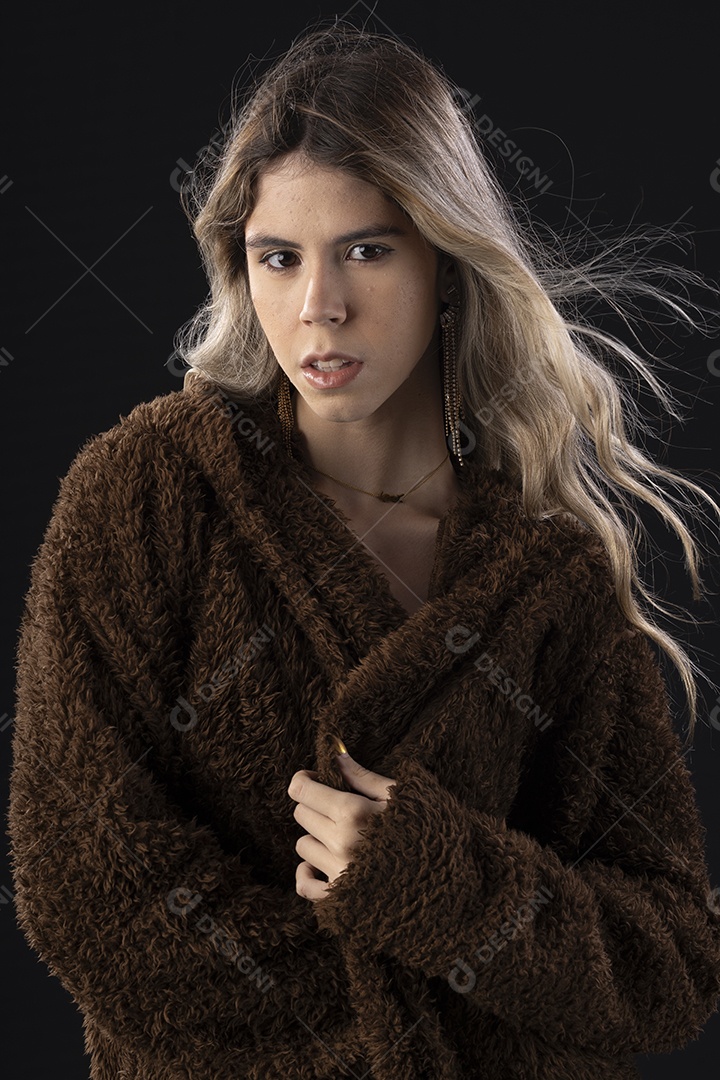 Jovem loira usando um vestido luxuoso em um fundo preto