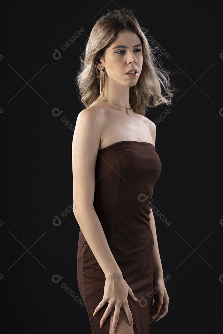 Jovem loira usando um vestido luxuoso em um fundo preto