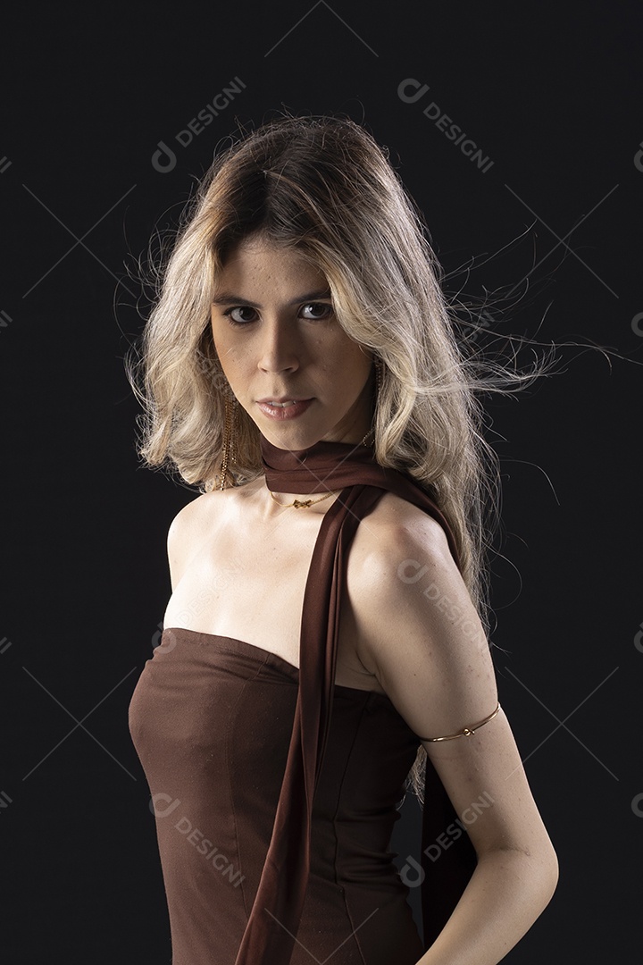 Jovem loira usando um vestido luxuoso em um fundo preto