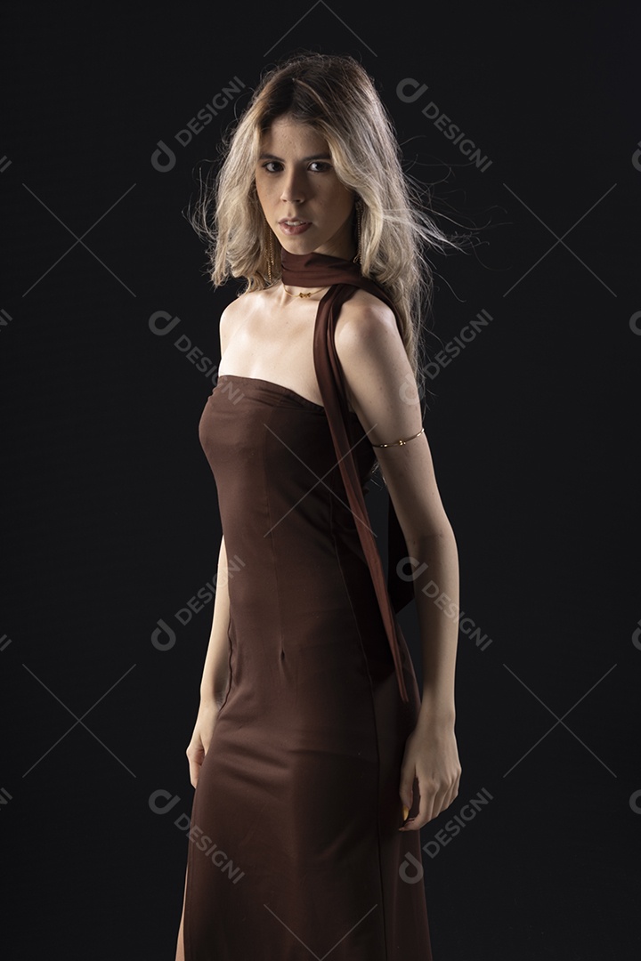 Jovem loira usando um vestido luxuoso em um fundo preto