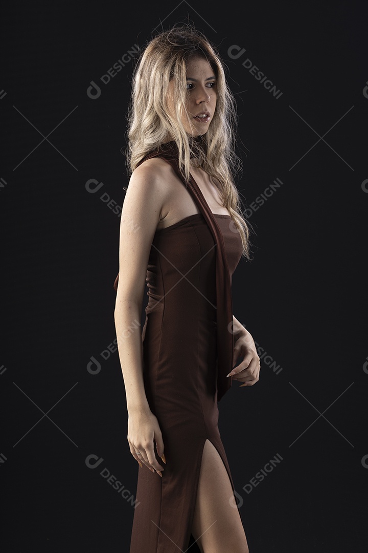 Jovem loira usando um vestido luxuoso em um fundo preto