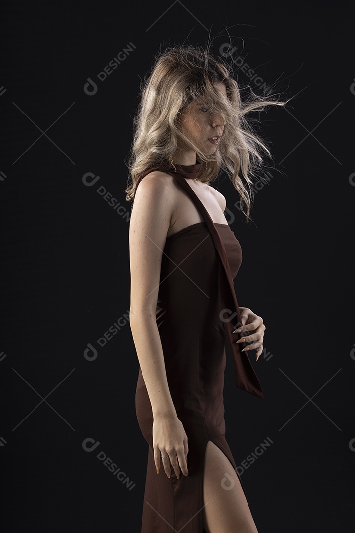 Jovem loira usando um vestido luxuoso em um fundo preto