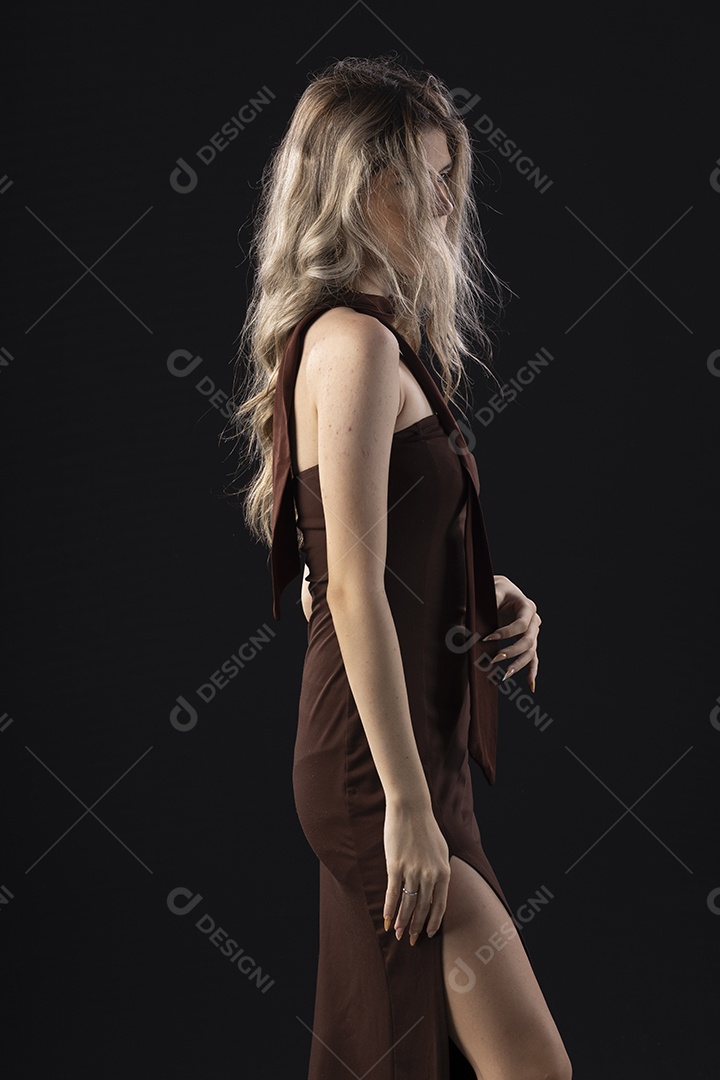 Jovem loira usando um vestido luxuoso em um fundo preto