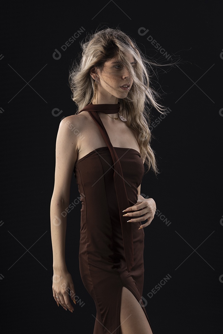 Jovem loira usando um vestido luxuoso em um fundo preto