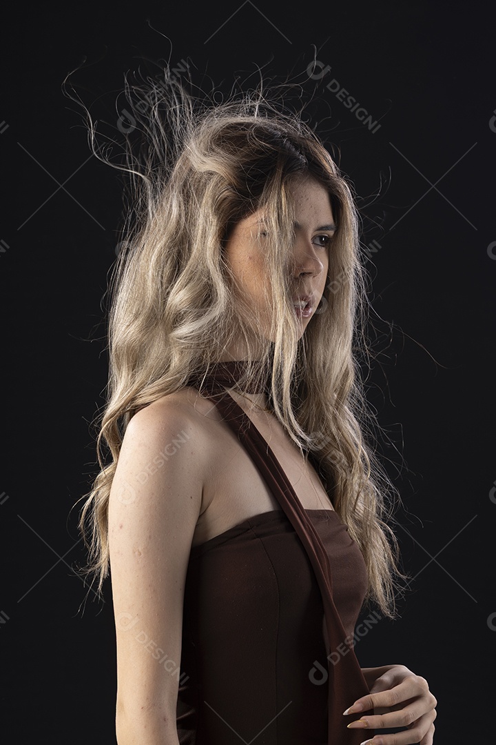 Jovem loira usando um vestido luxuoso em um fundo preto