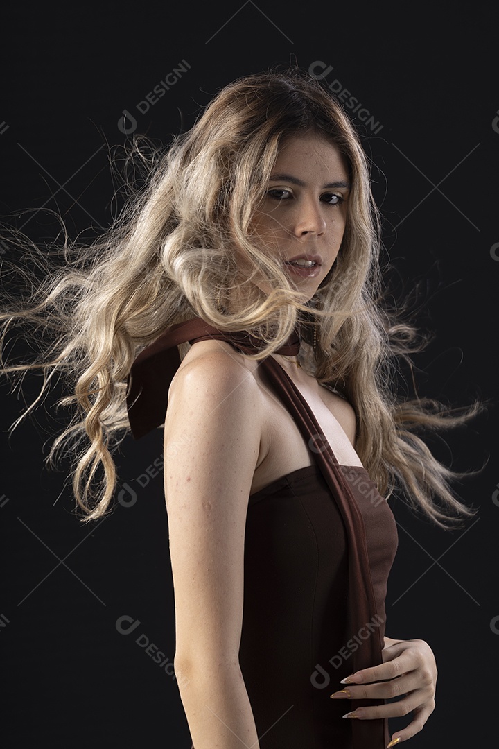 Jovem loira usando um vestido luxuoso em um fundo preto