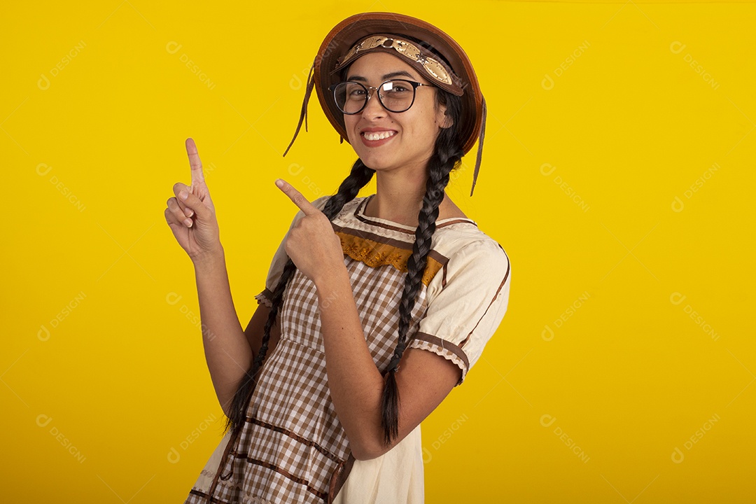 Mulher bonita com trajes de festa junina usando vestido e chapéu
