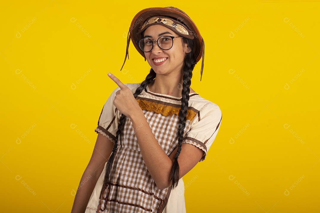Mulher bonita com trajes de festa junina usando vestido e chapéu