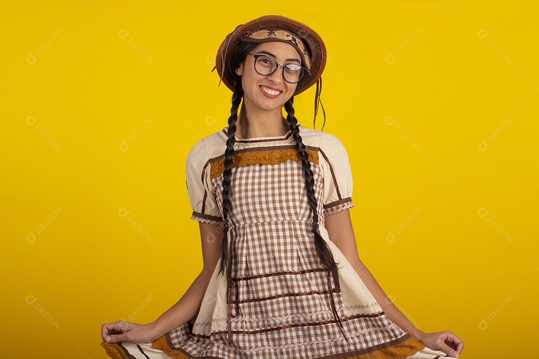 Mulher bonita com trajes de festa junina usando vestido e chapéu