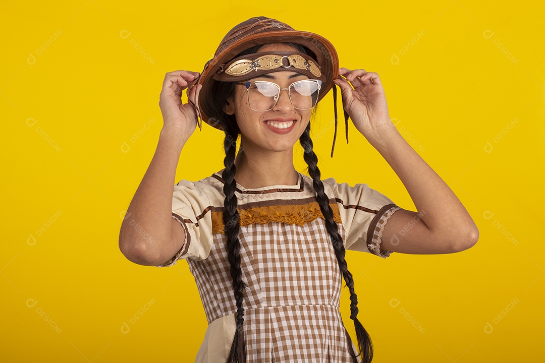 Mulher bonita com trajes de festa junina usando vestido e chapéu