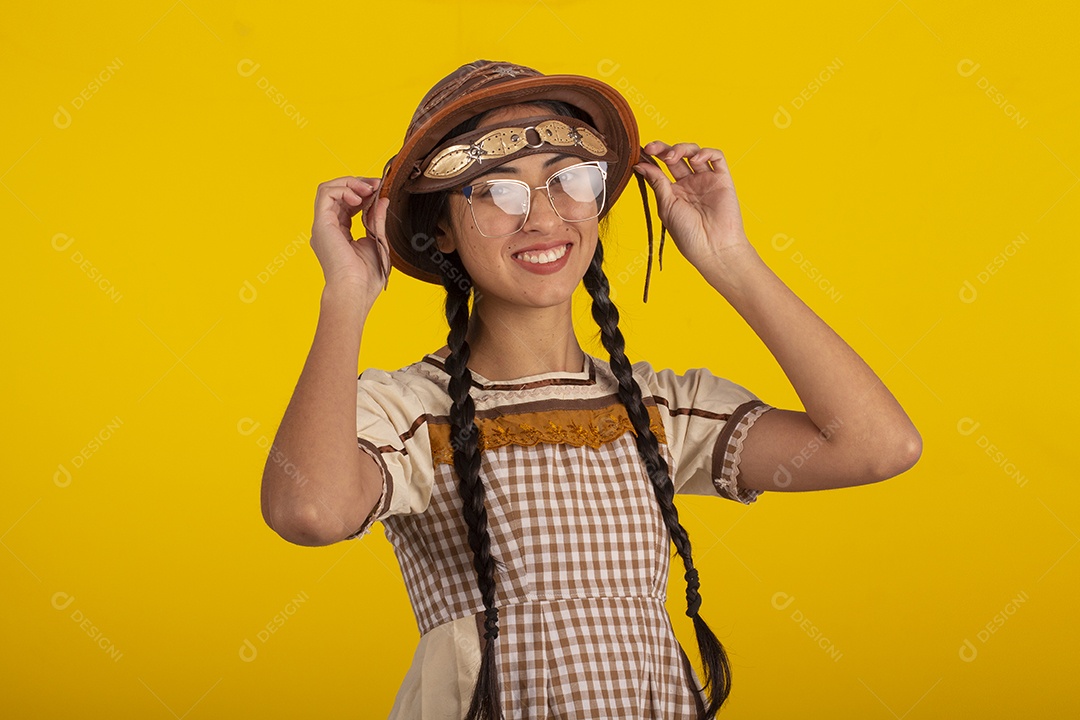 Mulher bonita com trajes de festa junina usando vestido e chapéu