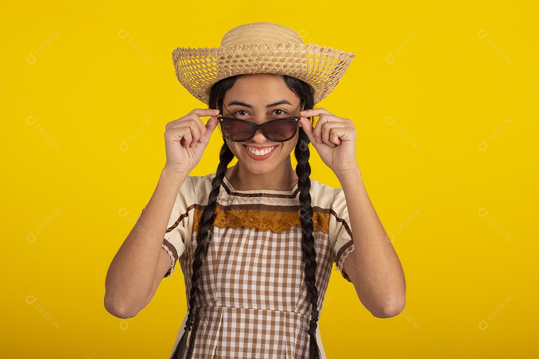 Mulher bonita com trajes de festa junina usando vestido e chapéu