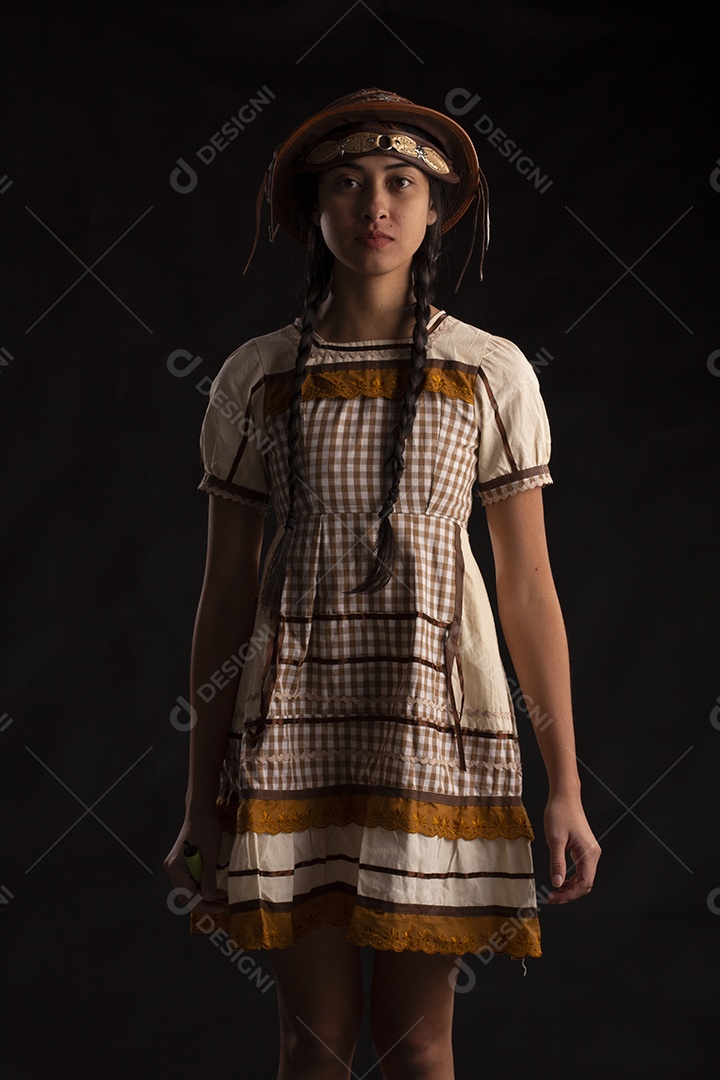 Jovem mulher em traje típico de festa junina com vestido e chapéu de couro