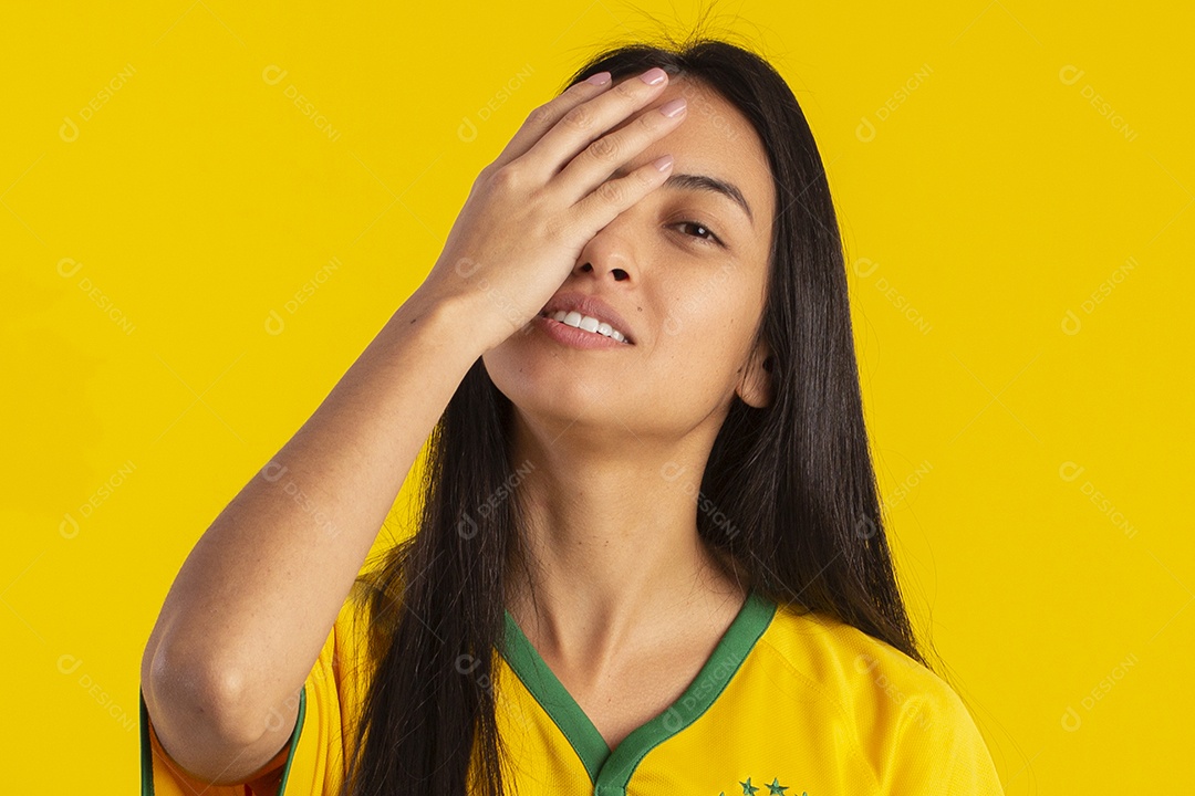 Jovem brasileira vestindo uma camisa amarela de time de futebol