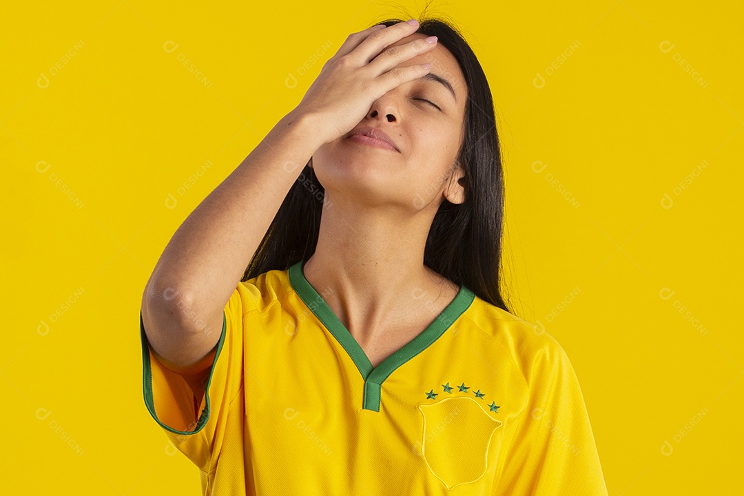 Jovem brasileira vestindo uma camisa amarela de time de futebol