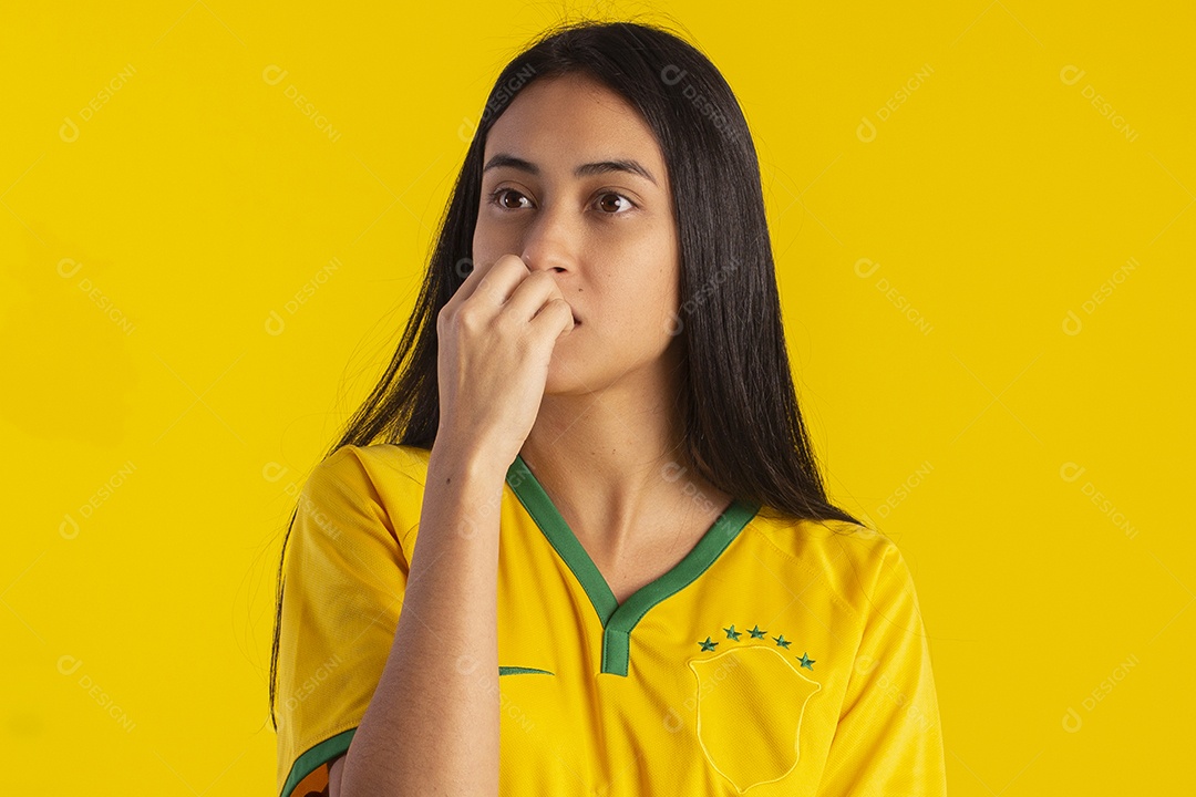 Jovem brasileira vestindo uma camisa amarela de time de futebol