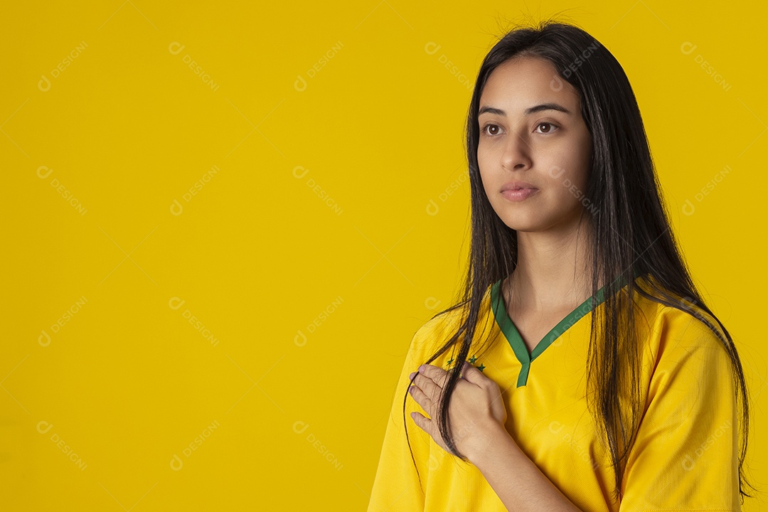 Jovem brasileira vestindo uma camisa amarela de time de futebol