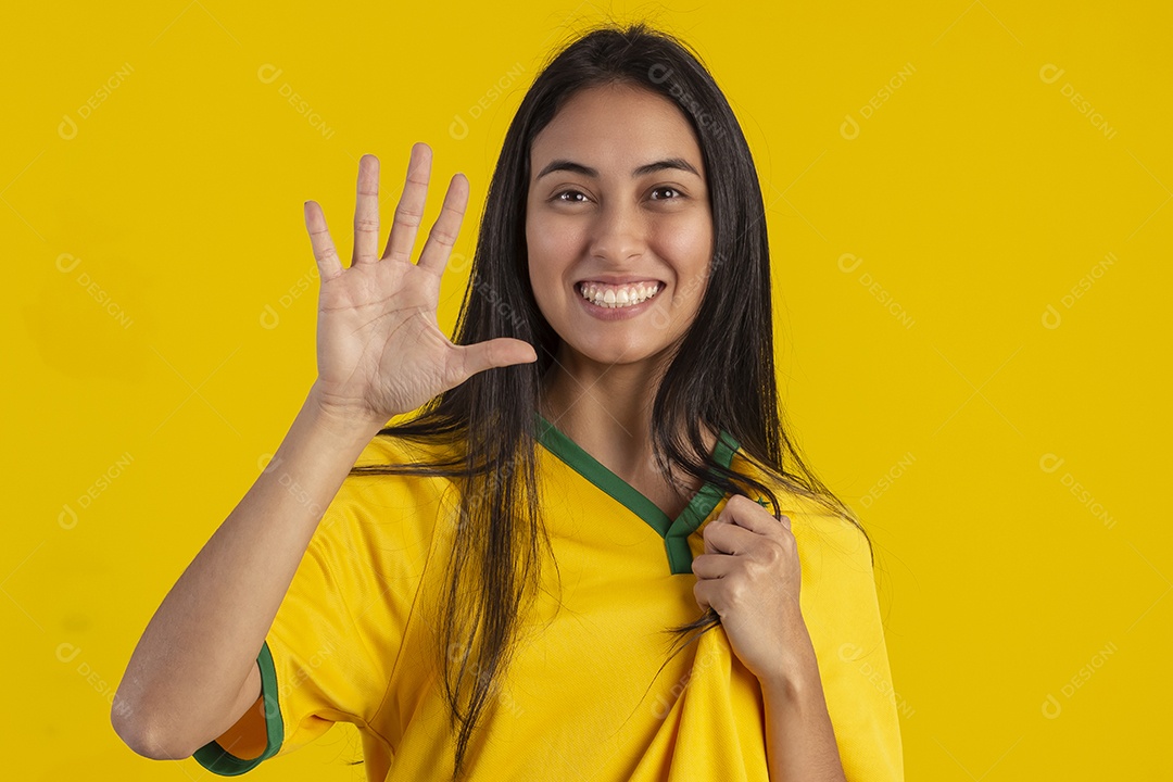 Jovem brasileira vestindo uma camisa amarela de time de futebol
