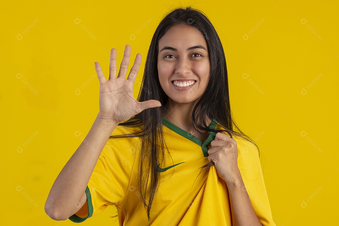 Jovem brasileira vestindo uma camisa amarela de time de futebol