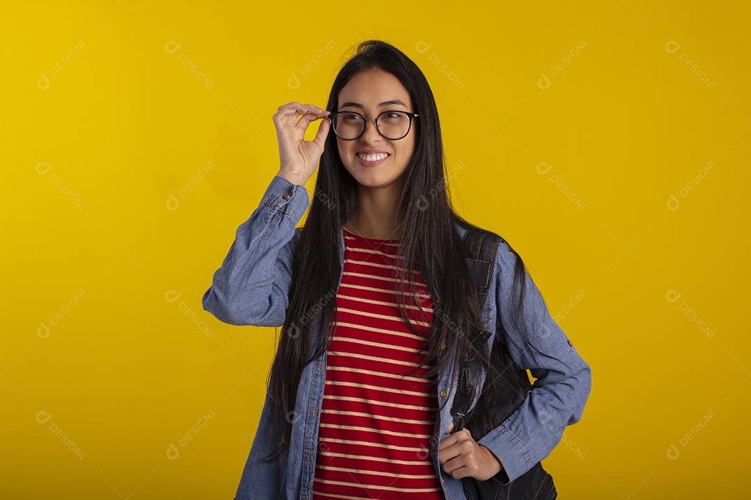 Estudante linda com mochila nas costas e mão no óculos
