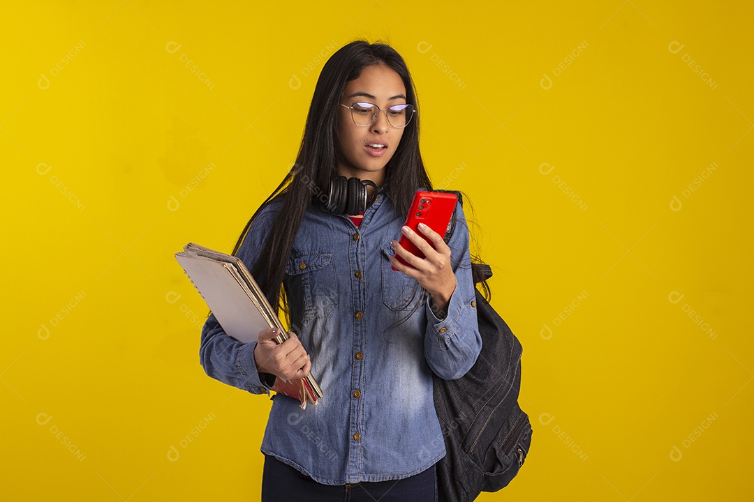 Estudante com livros e celular nas mãos