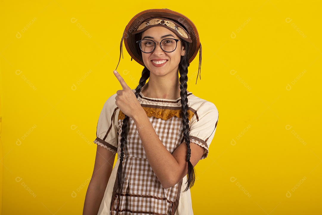 Mulher jovem bonita com trajes de festa junina usando vestido e chapéu