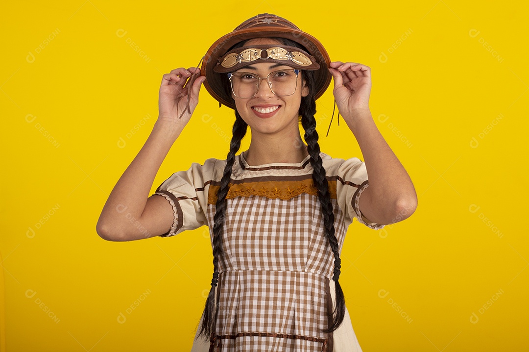 Jovem com trajes típico de festa junina vestido chapéu de couro segurando espingarda