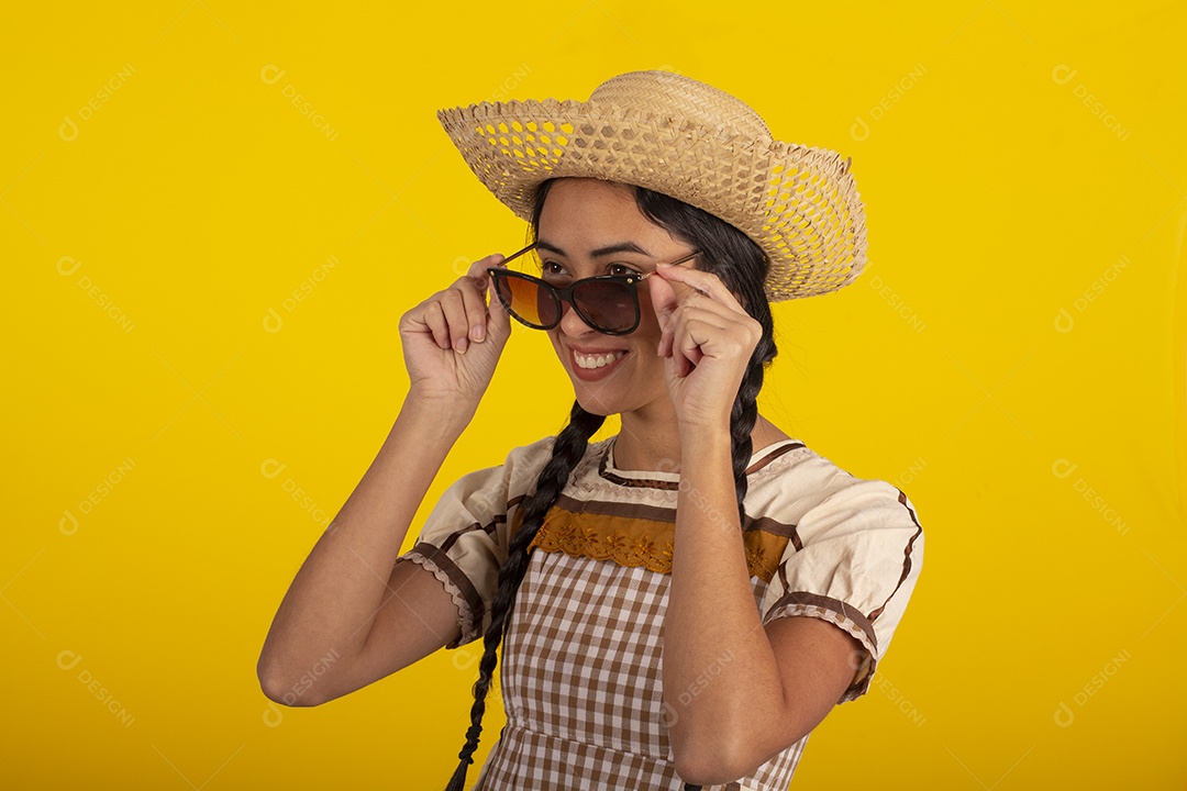 Jovem com trajes típico de festa junina vestido chapéu de couro segurando espingarda