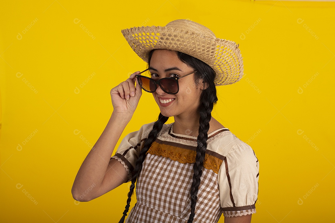 Jovem com trajes típico de festa junina vestido chapéu de couro segurando espingarda