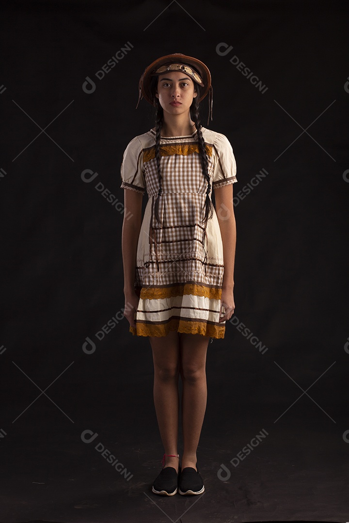 Jovem com trajes típico de festa junina vestido chapéu de couro segurando espingarda