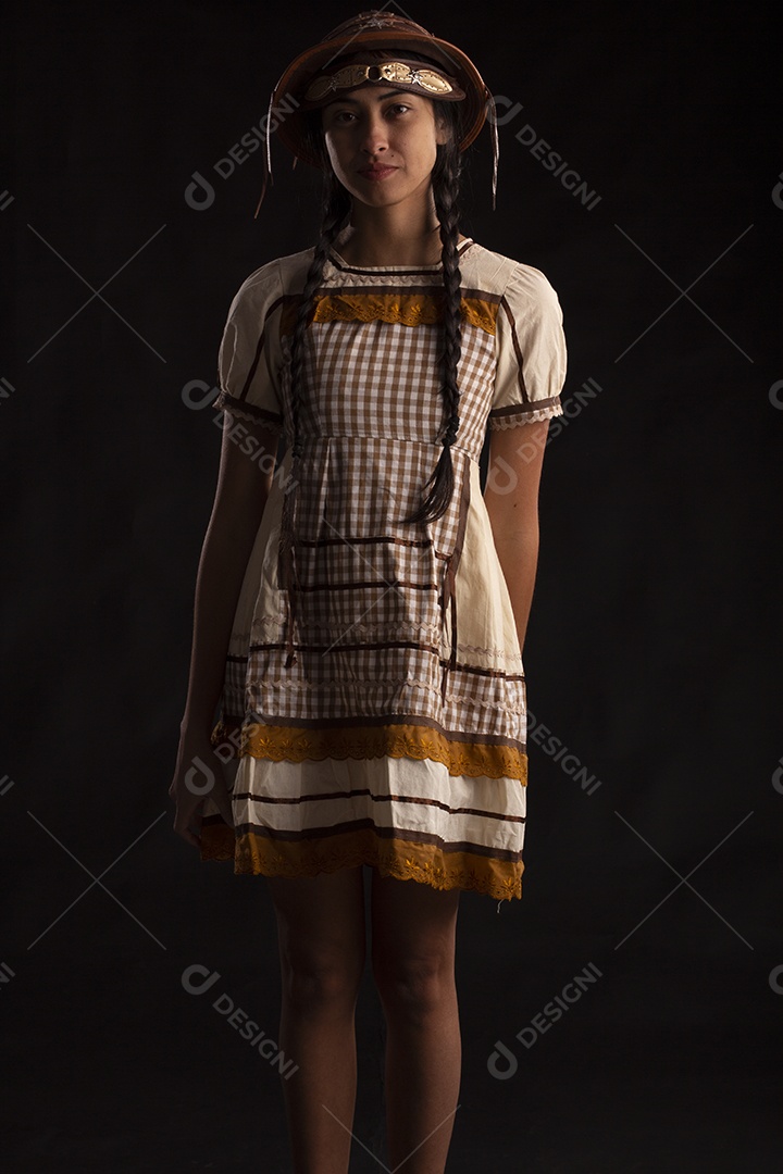 Jovem com trajes típico de festa junina vestido chapéu de couro segurando espingarda