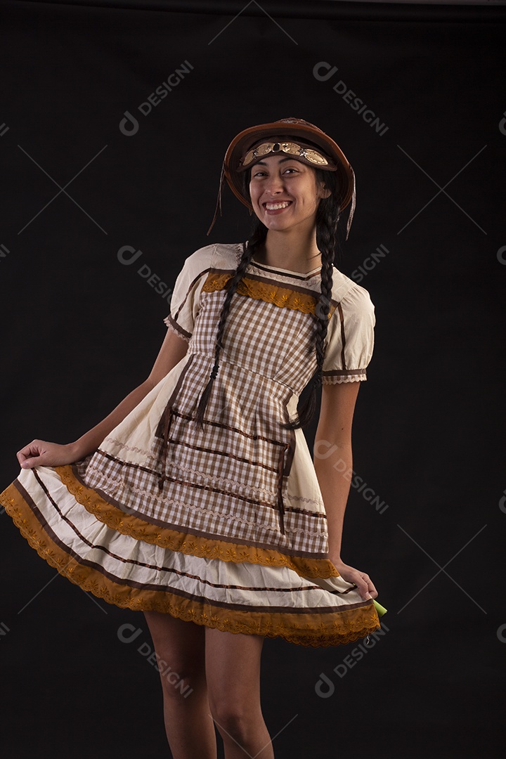 Jovem com trajes típico de festa junina vestido chapéu de couro segurando espingarda