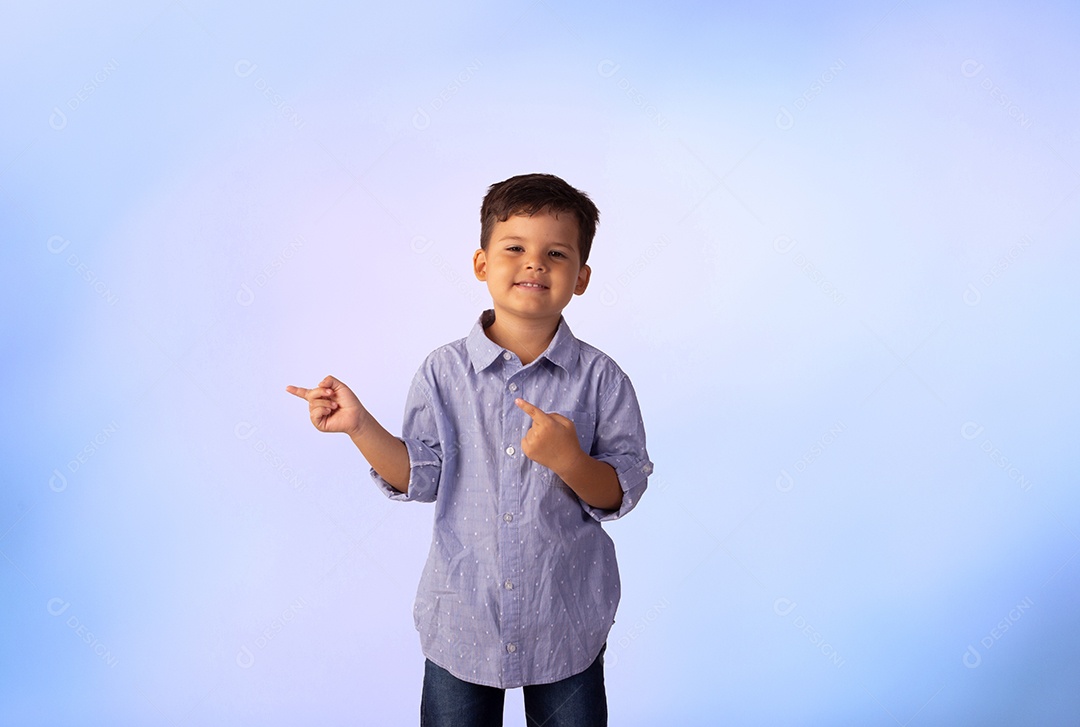 Criança do sexo masculino em foto de estúdio com fundo azul vestindo camisa e jeans