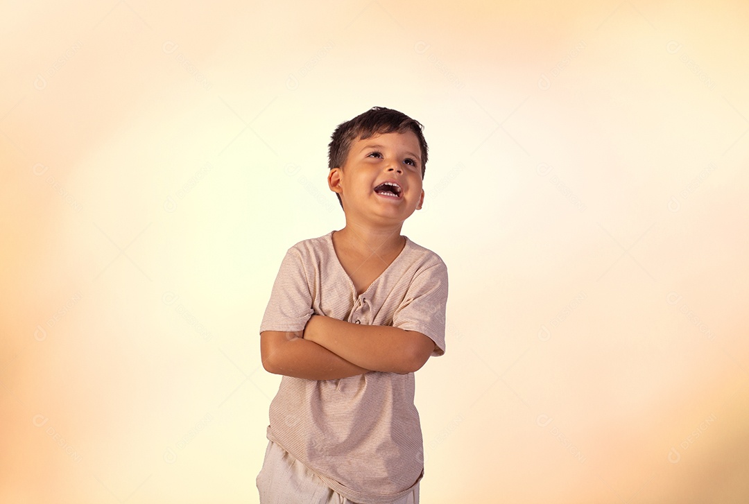 Criança do sexo masculino em foto de estúdio com fundo claro vestindo camisa e jeans