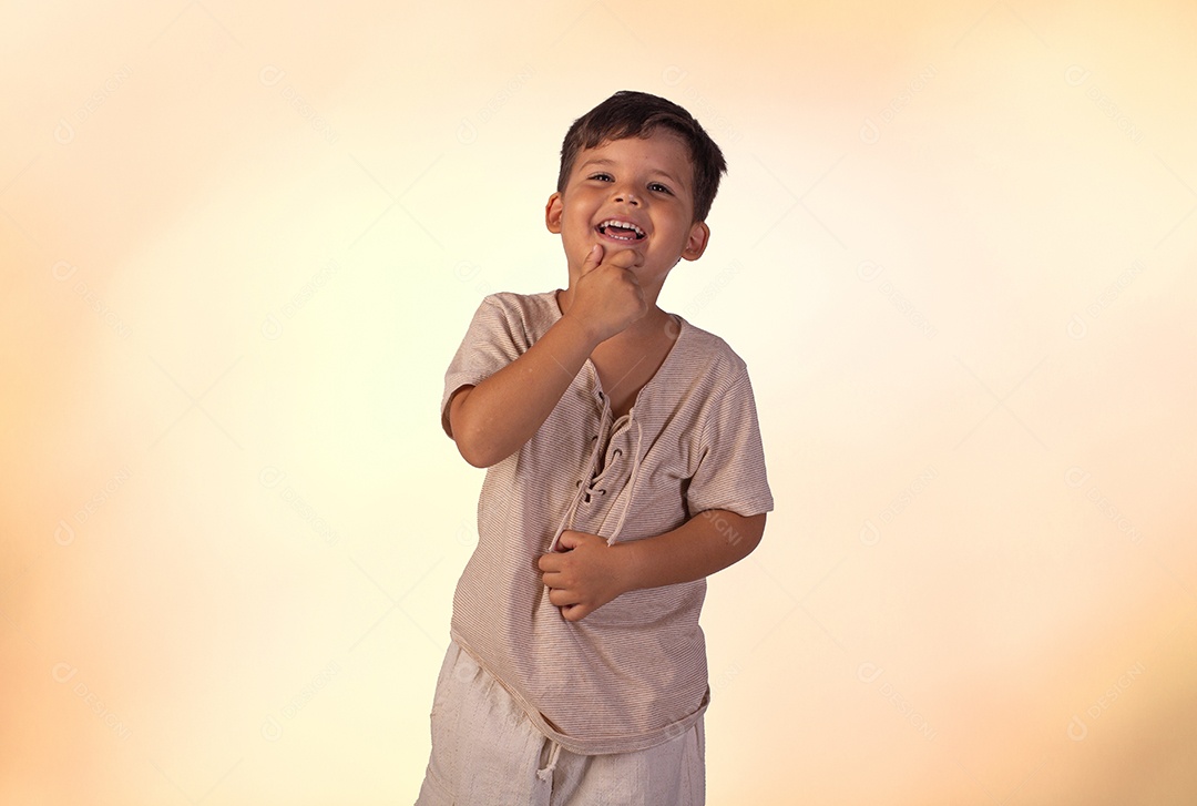 Criança do sexo masculino em foto de estúdio com fundo claro vestindo camisa e jeans