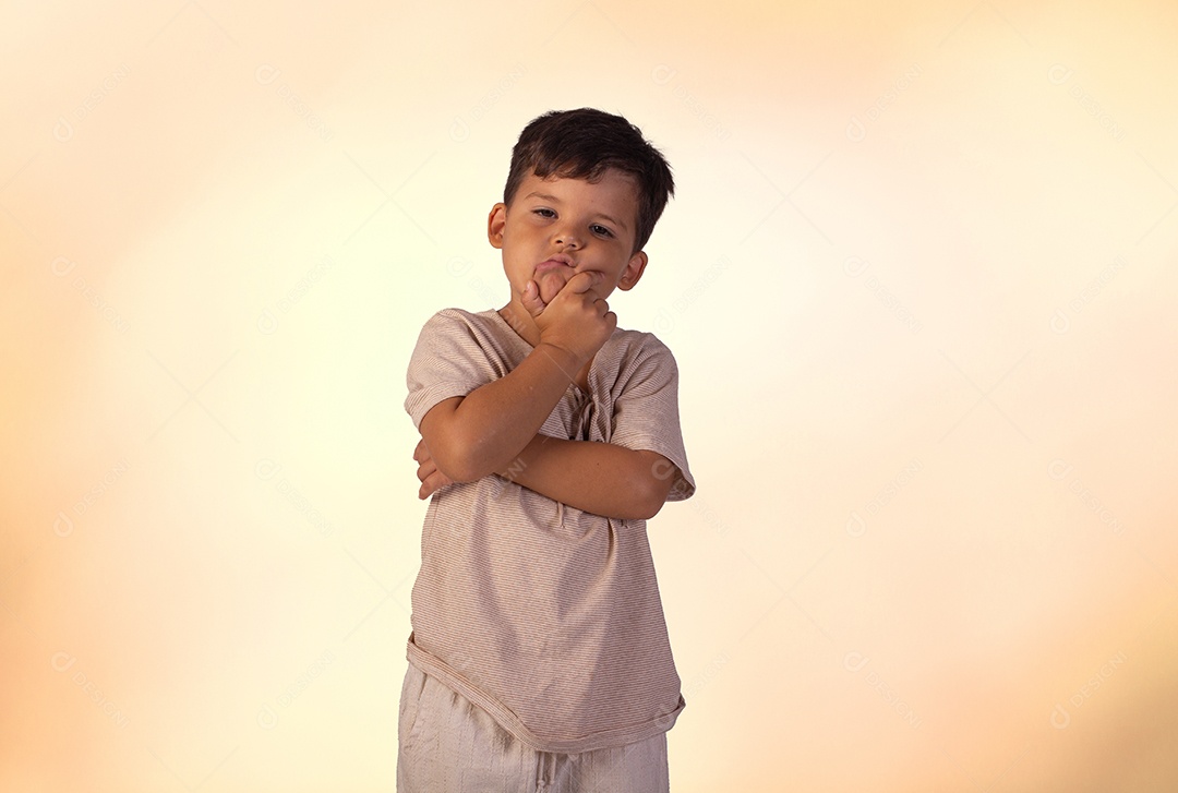 Criança do sexo masculino em foto de estúdio com fundo claro vestindo camisa e jeans