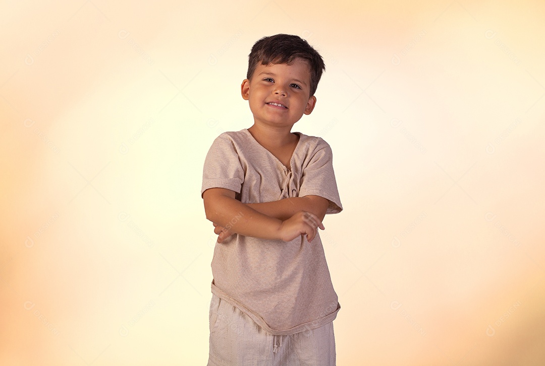 Criança do sexo masculino em foto de estúdio com fundo claro vestindo camisa e jeans