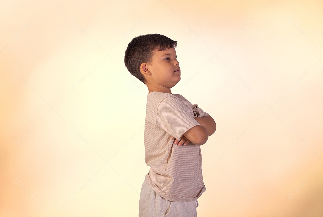 Criança do sexo masculino em foto de estúdio com fundo claro vestindo camisa e jeans