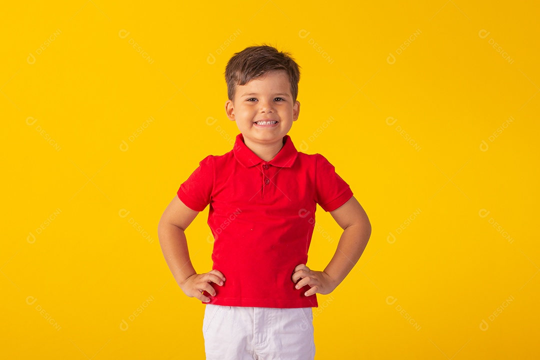 Criança do sexo masculino em foto de estúdio com fundo claro vestindo camisa e jeans