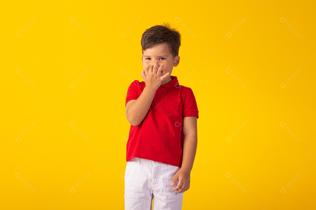 Criança do sexo masculino em foto de estúdio com fundo claro vestindo camisa e jeans