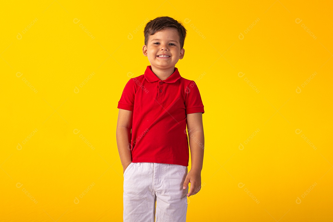 Criança do sexo masculino em foto de estúdio com fundo claro vestindo camisa e jeans