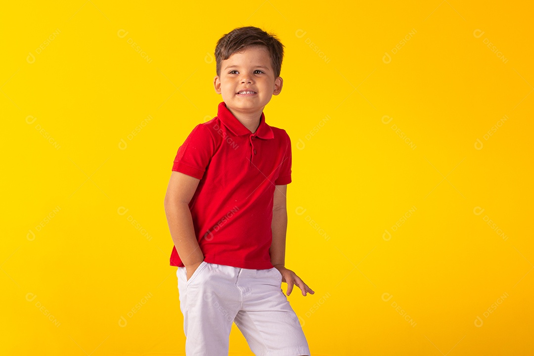 Criança do sexo masculino em foto de estúdio com fundo claro vestindo camisa e jeans