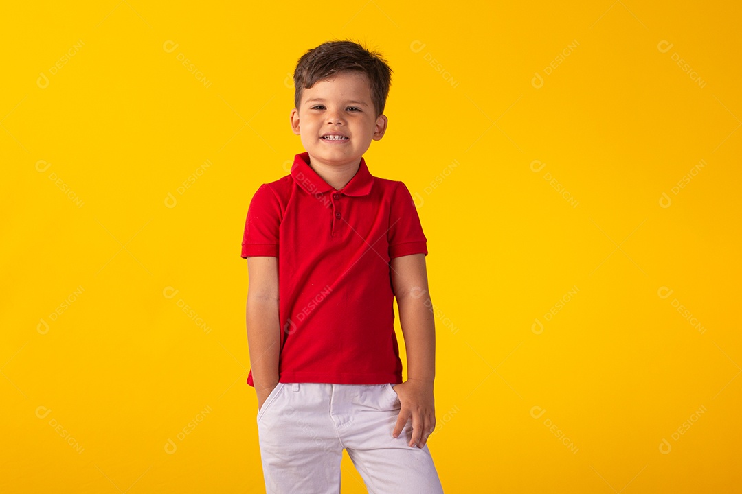 Criança do sexo masculino em foto de estúdio com fundo claro vestindo camisa e jeans